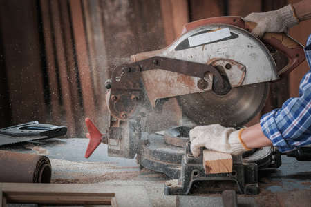 Strong man carpenter using table saw Industrial work conceptの写真素材