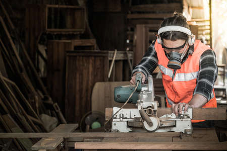 Strong man carpenter using table saw Industrial work conceptの写真素材