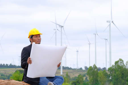 Engineers look at blueprints for clean energy wind turbine projects to generate electricity.の写真素材