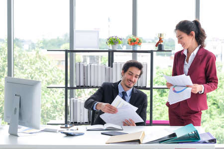 Business men and women collecting documents in the officeの写真素材