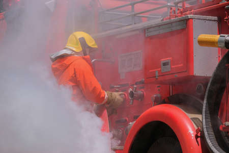 Firefighters drag fire hoses connected to fire truck hoses. in emergency situations caused by fireの写真素材