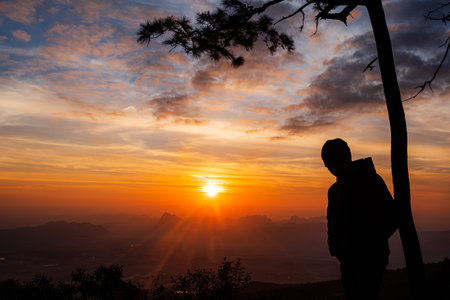 Silhouette of tourists watching the sunrise at Pha Nok Aen View Point Phu Kradueng National Park, Thailandの写真素材