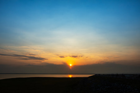 Gorgeous scenic of the strong sunrise with silver lining and cloud on the orange skyの写真素材