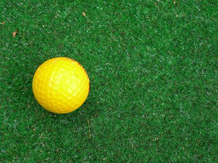 Golf ball on green plastic backgroundの写真素材