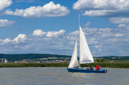 Three people on a sailing boat. Sailing lake Neusiedlersee, Austria.