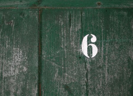 Number 6 written on an old weathered green doorの写真素材