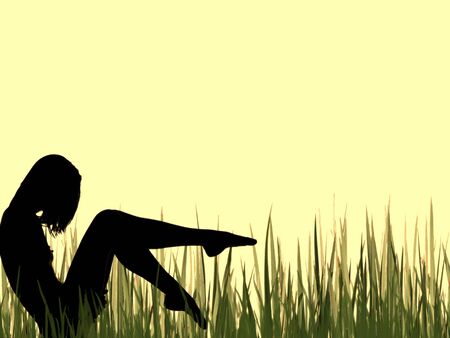 Female silhouette sitting in the grassの写真素材
