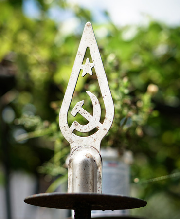Old coat of arms of the collapsed empire of the USSR on a blurred background. Tip on the flag of the Soviet Union. Historical photosのeditorial素材