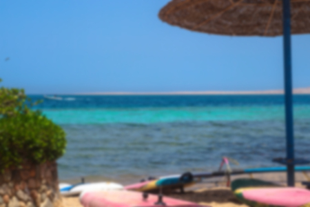 Blurred landscape on the sunny sea or ocean. Beautiful beach with sun loungers and umbrellas. Tourist backgroundの写真素材