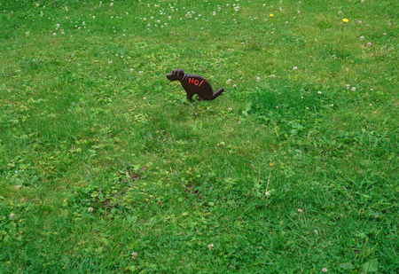 Image of a pet with a warning on a green lawn.  walking is prohibited.   for designの写真素材