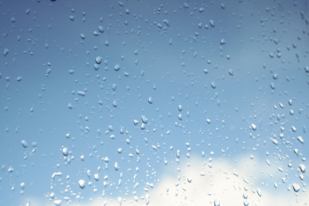 Beautiful raindrops on the window glass. Spring summer weather with warm rain.の写真素材
