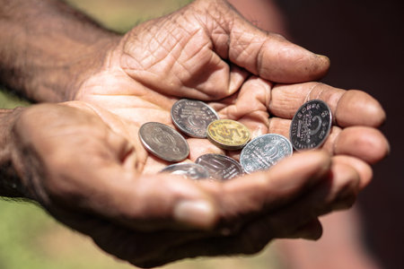 Coins in dark working hands. Beyond the poverty line in Asian countries. Subject soap bar.