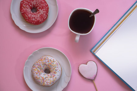 Beautiful juicy donuts with coffee in plates on a decorative tray. February valentine's day greeting card. background for kitchen designの写真素材