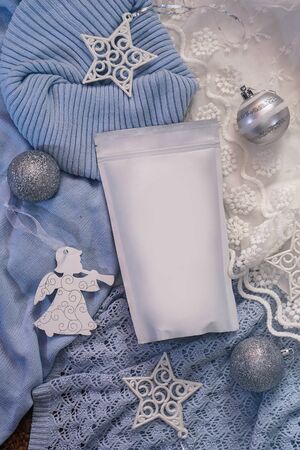 Template of ecological paper bag for storing coffee, tea on the background of decorations and adornments for the winter holiday. Vacuum packaging for christmas and new year presentの写真素材
