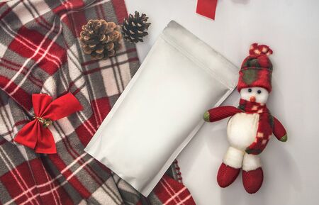 Template of ecological paper bag for storing coffee, tea on the background of decorations and adornments for the winter holiday. Vacuum packaging for christmas and new year presentの写真素材