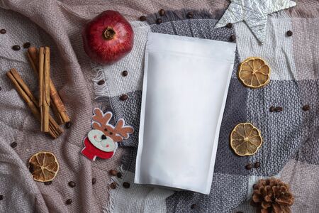 Template of ecological paper bag for storing coffee, tea on the background of dried fruits and decorations. Vacuum packaging for christmas and new year presentの写真素材