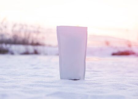 Template of paper ecological bag for storing coffee, tea on a background of a winter landscape. Vacuum packaging for christmas and new year presentの写真素材