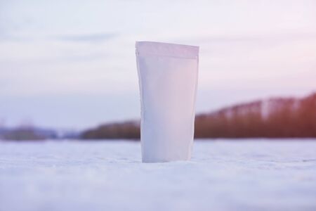 Template of paper ecological bag for storing coffee, tea on a background of a winter landscape. Vacuum packaging for christmas and new year presentの写真素材