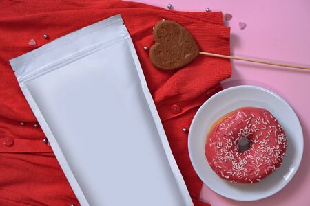 Paper packaging template on the background of romantic elements and a sweet donut. Mocap for branding your product on the package. Stock photo for designの写真素材