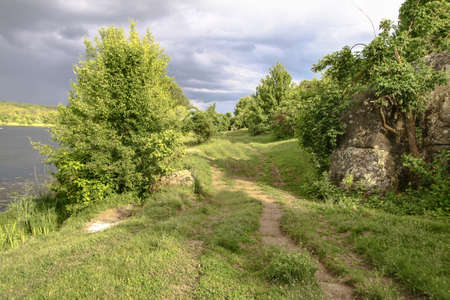 Field in the road among the hills. Landscape in nature in the reserve in the park. Stock photo backgroundの写真素材