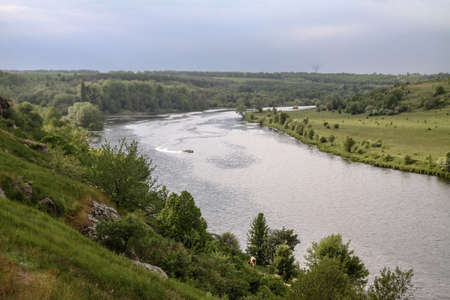 Top view of the river with a fast-moving motorboat with tourists in a nature reserve. Fishermen sail on the ship for the catch. Beautiful pretty landscape. Stock photoの写真素材