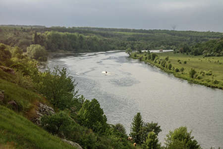 Top view of the river with a fast-moving motorboat with tourists in a nature reserve. Fishermen sail on the ship for the catch. Beautiful pretty landscape. Stock photoの写真素材
