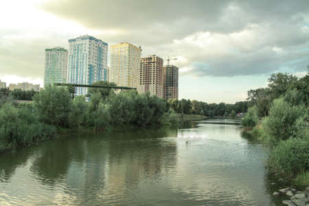 Building a house near the water in the park. Cityscapes with beautiful forest and trees. Stock photo background.の写真素材