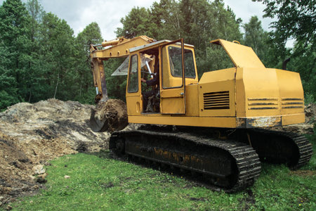 An excavator digs a large trench for building a house. A tractor digs a large lake that is already...