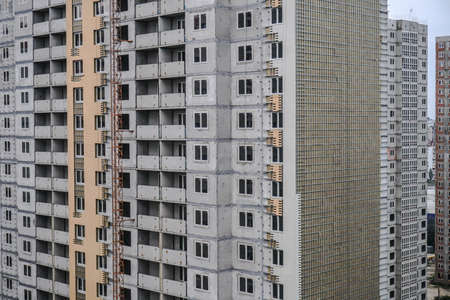 Large construction site on a background of blue sky. Brick, panel apartment building. Industrial theme for designの写真素材