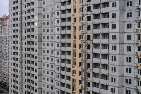 Large construction site on a background of blue sky. Brick, panel apartment building. Industrial theme for designの写真素材