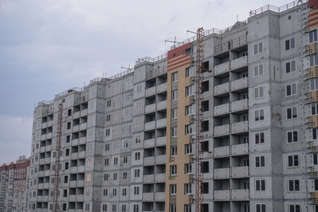 Large construction site on a background of blue sky. Brick, panel apartment building. industrial theme designの写真素材