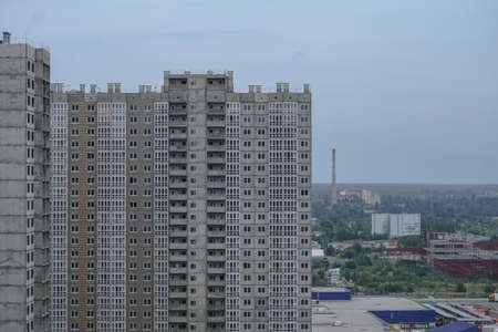 Large construction site on a background of blue sky. Brick, panel apartment building. Industrial theme for designの写真素材