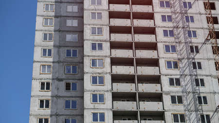 Large construction site on a background of blue sky. Brick, panel apartment building. Industrial theme for designの写真素材
