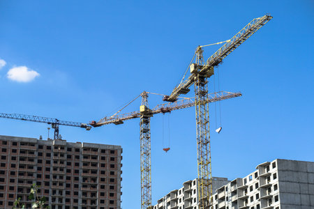 Multi-stage construction during the construction process with a yellow crane. Industrial background for design.の写真素材