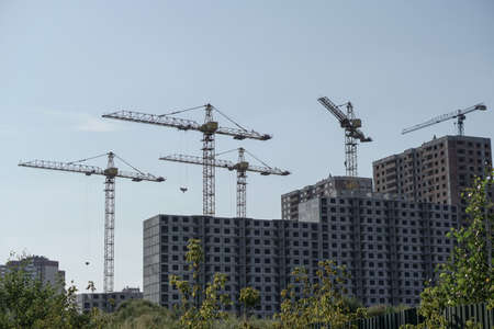 Multi-stage construction during the construction process with a yellow crane. Industrial background for design.の写真素材