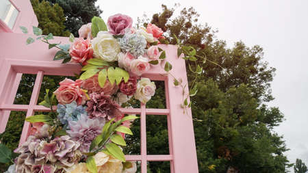 Flower design of a photo zone on the street with a telephone box. Colorful plants for the design of your home. Stock photo backgroundの写真素材