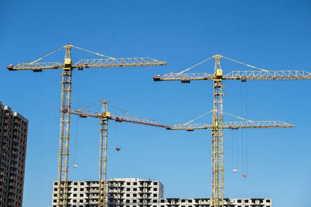 Multi-stage construction during the construction process with a yellow crane. Industrial background for design.の写真素材