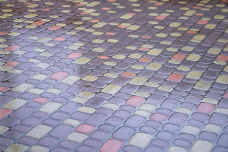 Multi-colored paving stones in the water. The texture of stones in the rain. Photo backgroundの写真素材