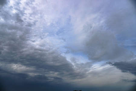 Scary thunderclouds and black trees. Night storm and dark cloud. Dark heaven backgroundの写真素材