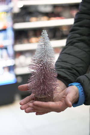 Beautiful Christmas tree toy in the hands of a man. Christmas present 2021の写真素材