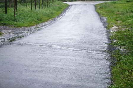 Road in poor condition is flooded with rain. Downpour and streams of water on the asphalt. Autumn backgroundの写真素材