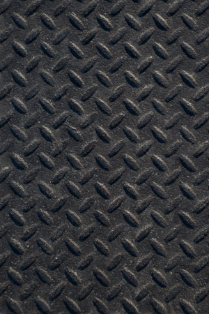 Closeup of distressed, mottled, grungy industrial checker plate rusty metal background texture with...
