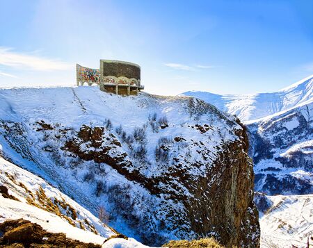 Georgia. Circa November, 2017. The friendship monument of Georgia is illuminated by sun light as it sits on a beautiful mountain of snow.の写真素材