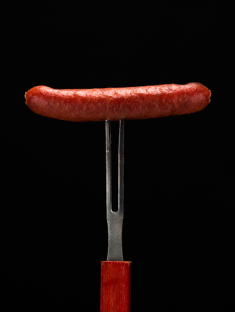 Smoked sausage on the fork, vertical.の写真素材