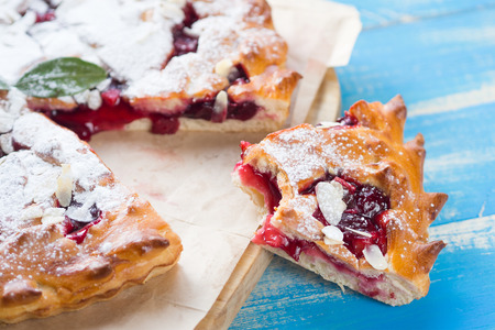 Bitten slice of pie on the blue wooden background.の写真素材