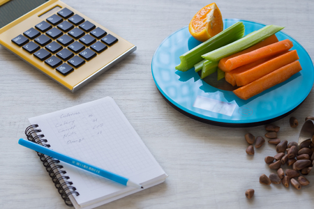 Vegetables and nuts on the scales. Calorie counting.の写真素材