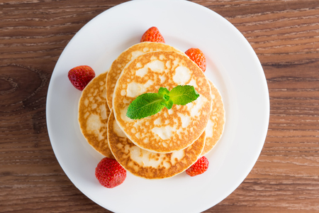 Pancakes (fritters) with strawberries on a plate. Top of view.の写真素材