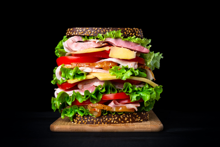 Huge appetizing sandwich on a black background.の写真素材
