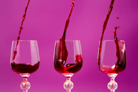 Rose (red) wine is poured into a glass with splash. 3 in 1.の写真素材
