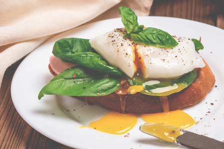 Healthy breakfast with wholemeal bread toast and poached egg with basilicus.の写真素材